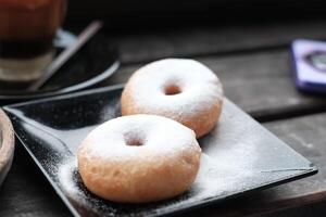 Fresh donuts sprinkled with powdersar, perfect for breakfast or a sweet snack. photo