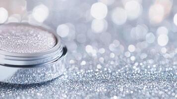 Shimmering eyeshadow cosmetic palette lying against glittery, blurred silver background photo
