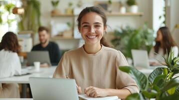 Woman business developer working on desktop computer, surrounded by lush houseplants in sunlit online design workspace with modern office photo
