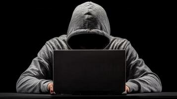 Hooded hacker typing privacy laptop in shadowy workspace, representing cybersecurity threat and digital on breach cyber risk photo