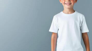 Smiling blond child boy white t shirt mockup posing confidently during studio photoshoot against neutral gray background photo