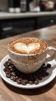 A cup of cozy coffee the latte art in with shape of a heart, valentine love, coffee beans adorning ceramic saucer. Vertical format photo