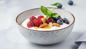 Creamy Greek yogurt topped with honey in glass bowl food almonds, blackberries, redcurrants, drizzled with syrup with nutritious morning treat photo