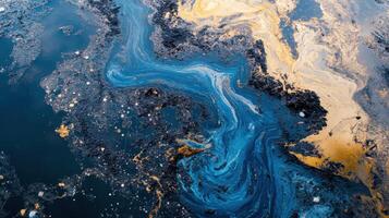 Oil slick creating swirling patterns on water surface with contrasting colors observed in a coastal area under bright sunlight during the afternoon photo