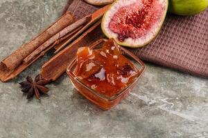 Figs, cinnamon sticks and an apple on a table photo
