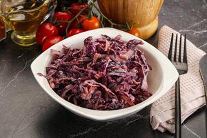 A bowl of red cabbage with a knife and fork photo