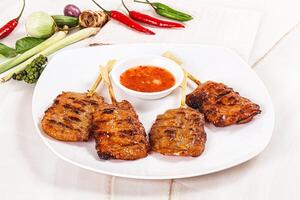 A plate of food with skewers and sauce photo
