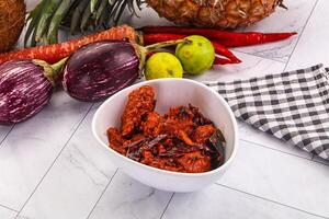 A bowl of food with a pineapple, carrots, and other vegetables photo