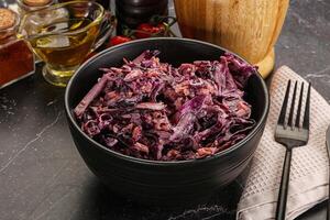 A bowl of red cabbage with a fork and knife photo