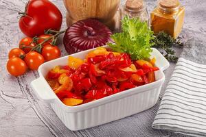 A white dish with tomatoes, peppers, and onions photo