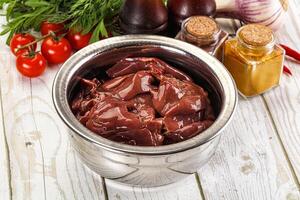 A bowl of meat and vegetables on a table photo