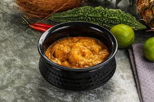 A bowl of curry with pineapple, lime and cilantro photo
