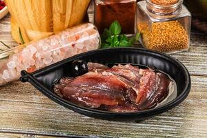 A bowl of raw meat sitting on a table next to spices and other ingredients photo