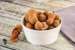 A bowl filled with nuts on a wooden table photo
