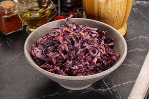 A bowl of red cabbage sitting on a table photo