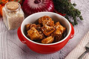 A bowl of meat and vegetables on a table photo