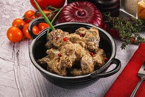 A bowl of meat and vegetables on a table photo