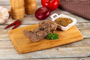 A wooden cutting board with meat and spices photo