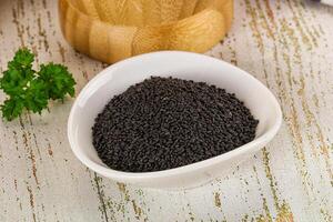 A bowl of black seeds on a table photo