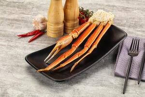 A plate with a crab leg on it and a knife and fork photo