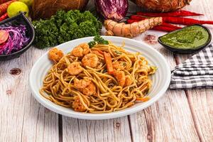 A plate of noodles and vegetables on a table photo