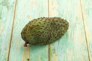 A single fruit on a wooden surface photo