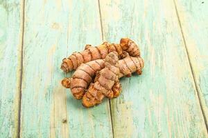 A pile of raw ginger on a wooden table photo