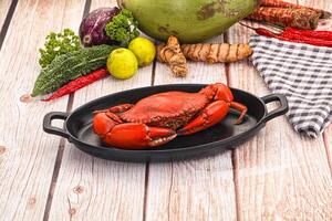 A crab in a pan on a wooden table photo