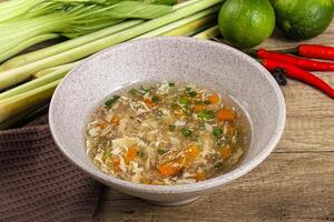 A bowl of soup with vegetables and a knife photo