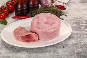 A plate with a ham and some vegetables on it photo