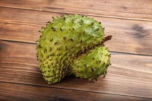 A single green fruit on a wooden table photo