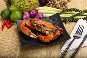 A plate with a crab, vegetables and a knife photo