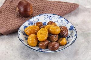 A bowl of dried dates and a towel on a table photo
