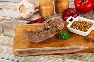 A wooden cutting board with meat, spices and vegetables photo