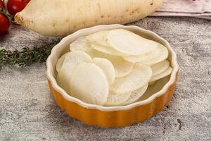 A bowl filled with sliced potatoes and tomatoes photo