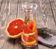 A glass pitcher with a slice of grapefruit and a towel photo