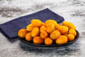A bowl of oranges and a napkin on a table photo