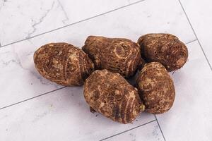 A group of potatoes on a white surface photo