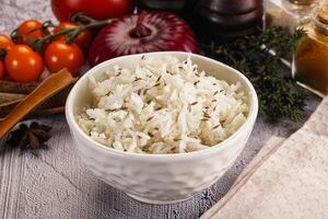 A bowl of rice with spices and vegetables on a table photo
