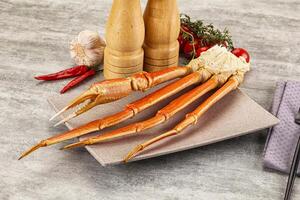A plate with a crab leg and a knife and fork photo