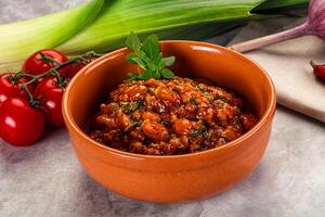 A bowl of chili with tomatoes and onions photo