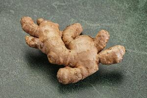 A ginger root on a green surface photo