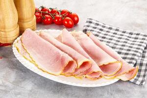 Ham slices on a plate with tomatoes and a knife photo