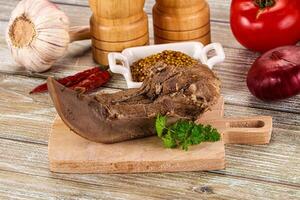 A piece of meat on a cutting board with spices and other ingredients photo