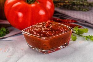 A bowl of sauce with tomatoes and herbs photo