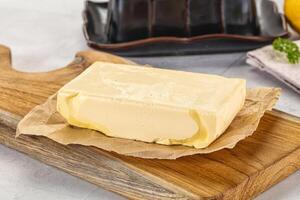 A block of butter sits on a cutting board photo