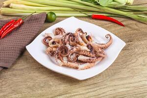 A plate of octopus on a table with other vegetables photo