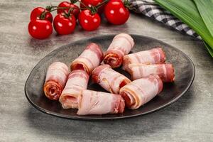 Bacon wrapped in ham on a plate with tomatoes photo
