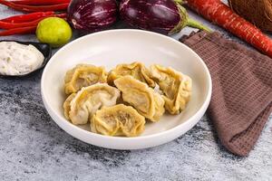 A bowl of dumplings with vegetables and spices photo