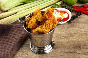 A silver container with fried shrimp and other vegetables photo